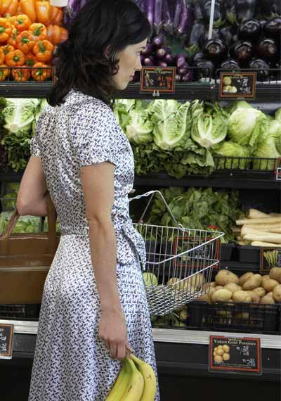 woman shopping in produce section of grocery store