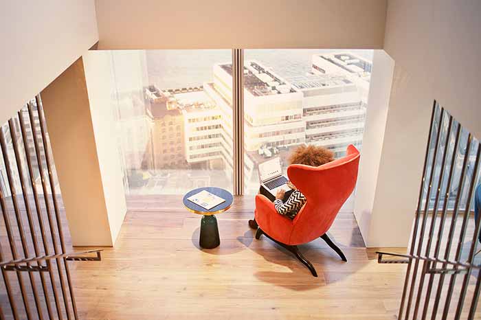 woman sitting in chair looking out window in office